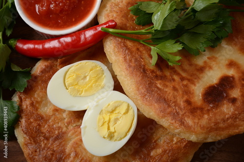 Traditional dishes of Israeli and Middle Eastern cuisine - Malawach with hard boiled eggs and tomatoes.  Malawach or malawah: traditional fried bread of Yemenite Jews photo