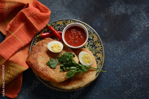 Traditional dishes of Israeli and Middle Eastern cuisine - Malawach with hard boiled eggs and tomatoes.  Malawach or malawah: traditional fried bread of Yemenite Jews photo