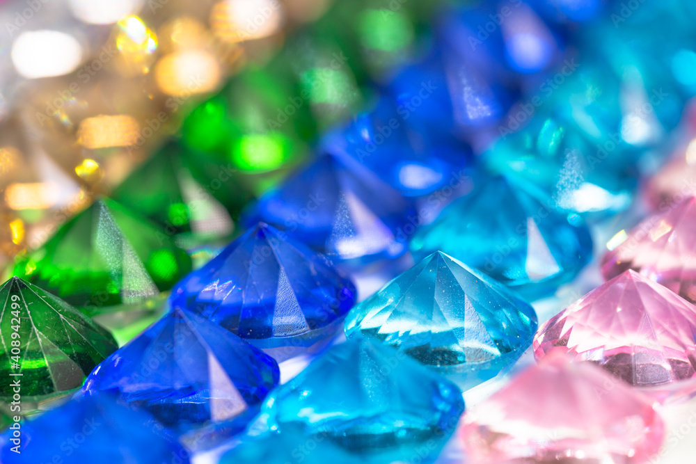 .Colorful diamonds are arranged neatly in a row on a white floor.
