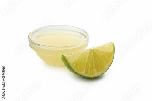 Glass bowl with lime juice and slice isolated on white background © Atlas