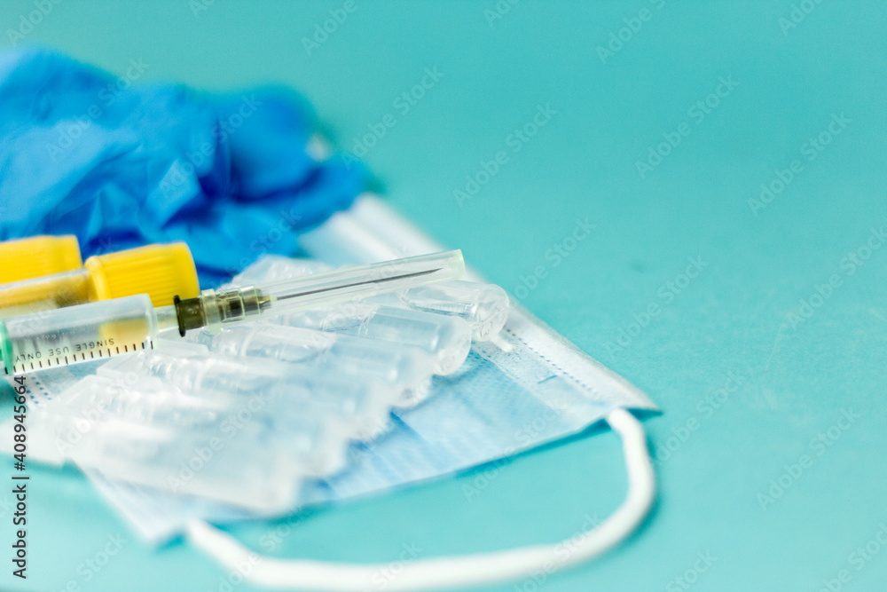Medical vials for injection, syringe for injection, mask gloves on a blue background. Admission vaccination, flu shot.