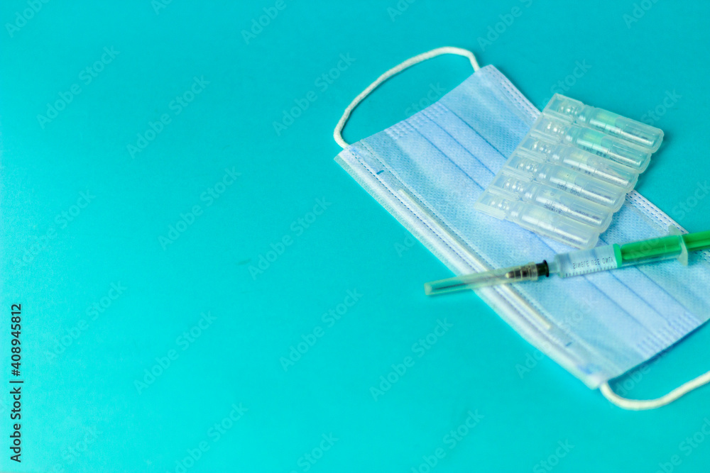 Medical vials for injection, syringe for injection, mask gloves on a blue background. Admission vaccination, flu shot. Medical vials for injection, syringe for injection, mask gloves on a blue background. Admission vaccination, flu shot.