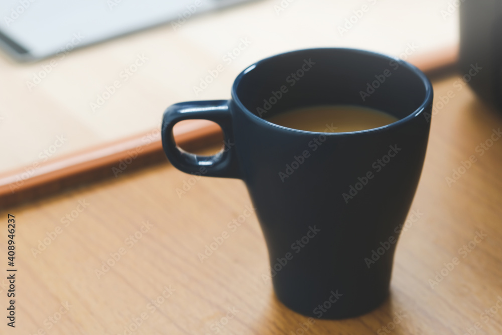 Close-up a Cup of coffee on wooden desk in morning at the office. Close-up a Cup of coffee on wooden desk in morning at the office.