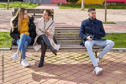 Wall Mural Two angry blonde girls sitting on a bench next to a boy