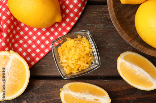 Grated lemon zest and fresh fruits on wooden table, flat lay