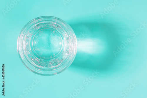 Glass cup with water on blue background  top view