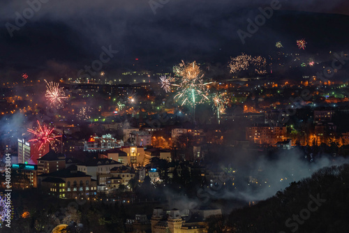 Fireworks illuminate the sky with a dazzling spectacle. Colorful fireworks over the city with bokeh background. Abstract festive background © Tatyana Obolevich