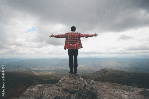 A man stand on the top mountain cliff and acting of freedom life style travel trip successful background textures concept. © Thepphanom