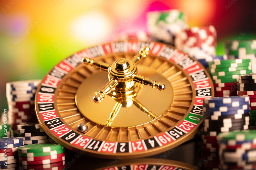 Casino theme. Roulette wheel, poker chips and dice on colorful bokeh background. Casino theme. Roulette wheel, poker chips and dice on colorful bokeh background.
