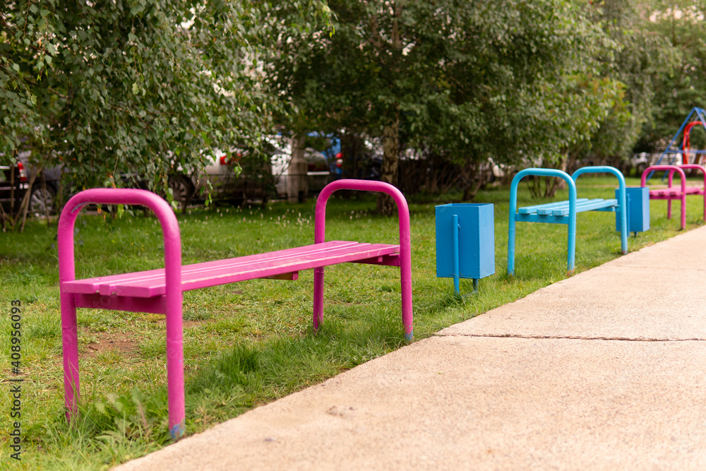 Coloured benches in a park. Empty benchesWalking area in the russian city. Selective focus.