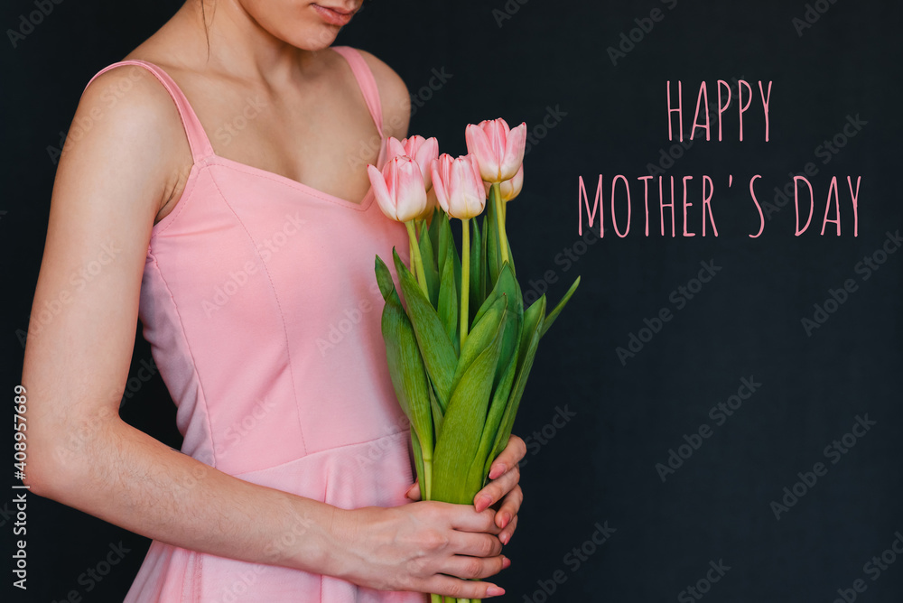 bouquet of flowers of pink tulips in the hands of a girl. Greeting card with text Happy Mother's Day bouquet of flowers of pink tulips in the hands of a girl. Greeting card with text Happy Mother's Day