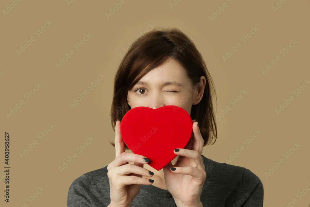Portrait of young woman with red heart shaped gift box. Happiness, valentines day and love concept. Portrait of young woman with red heart shaped gift box. Happiness, valentines day and love concept.