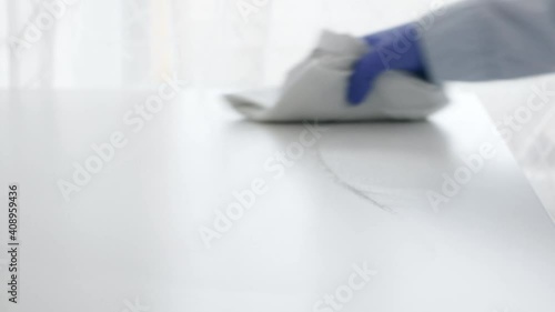 Cleaning home table sanitizing workplace table surface with disinfectant spray bottle washing surfaces and gloves. COVID-19 prevention sanitizing inside.