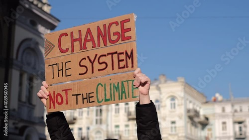 Solo picket protest in city square save the planet concept with slogan Change the System not the climate  