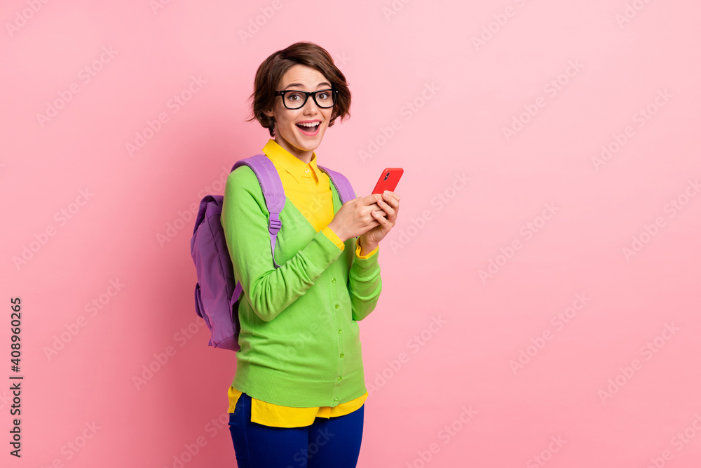 Photo of excited woman wear green cardigan spectacles rucksack holding modern gadget empty space isolated pink color background Photo of excited woman wear green cardigan spectacles rucksack holding modern gadget empty space isolated pink color background
