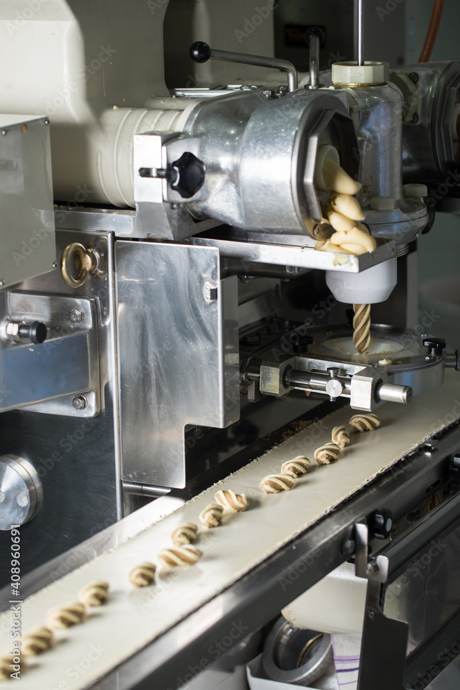 Cookies making process, many raw cookies on conveyor belt Cookies making process, many raw cookies on conveyor belt