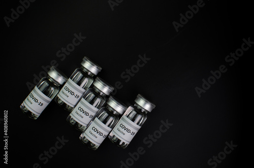 Coronavirus vaccine bottle flipped isolated on black background. Covid-19 situation disease pharmacy in laboratory and drug to cure people. Healthcare and Medical concept. Development of research.