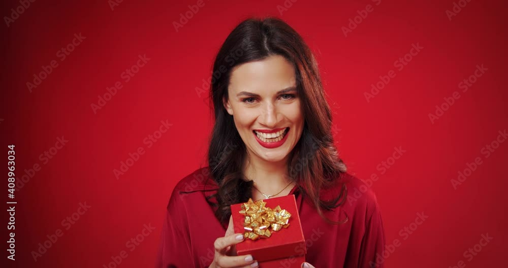 beautiful woman enjoys a valentine's gift on a red background beautiful woman enjoys a valentine's gift on a red background