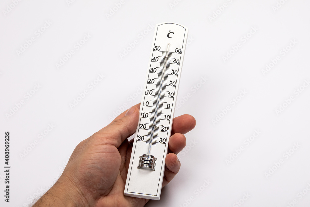 Wooden thermometer with Celsius scale in a man's hand on a white background Wooden thermometer with Celsius scale in a man's hand on a white background