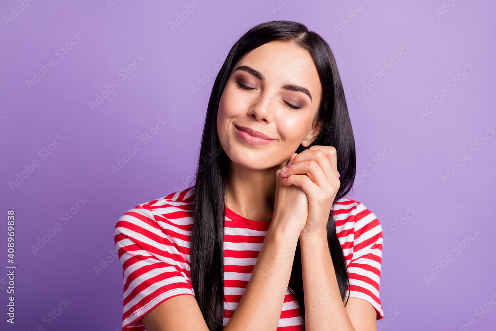 Photo of dreamy peaceful young woman imagine girl hands together closed eyes isolated on violet color background Photo of dreamy peaceful young woman imagine girl hands together closed eyes isolated on violet color background