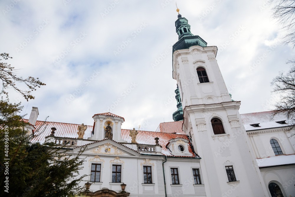 Strahov Monastery with White Baroque church, Premonstratensian abbey in Bohemia under snow, Basilica of the Assumption of Virgin Mary in winter day, Hradcany, Prague, Czech Republic