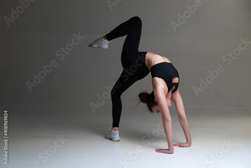 Woman performs acrabatic exercise. Handstand.