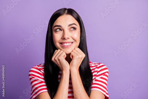 Photo of adorable cute girl look dreamy empty space hold hands chin isolated on violet color background photo