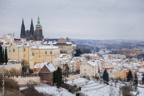 Panoramic view of Prague Castle, St. Vitus Cathedral with baroque and renaissance historical buildings from Petrin Hill, snow, winter day, Hradcany district, Prague, Czech Republic