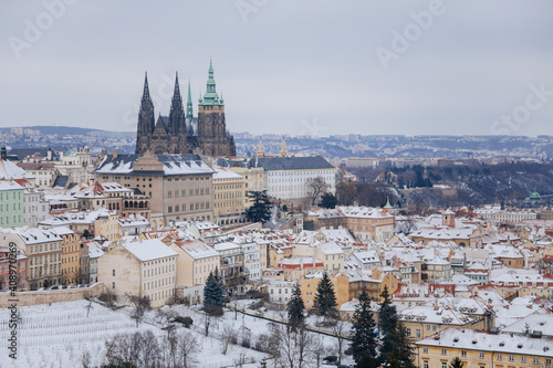 Panoramic view of Prague Castle, St. Vitus Cathedral with baroque and renaissance historical buildings from Petrin Hill, snow, winter day, Hradcany district, Prague, Czech Republic