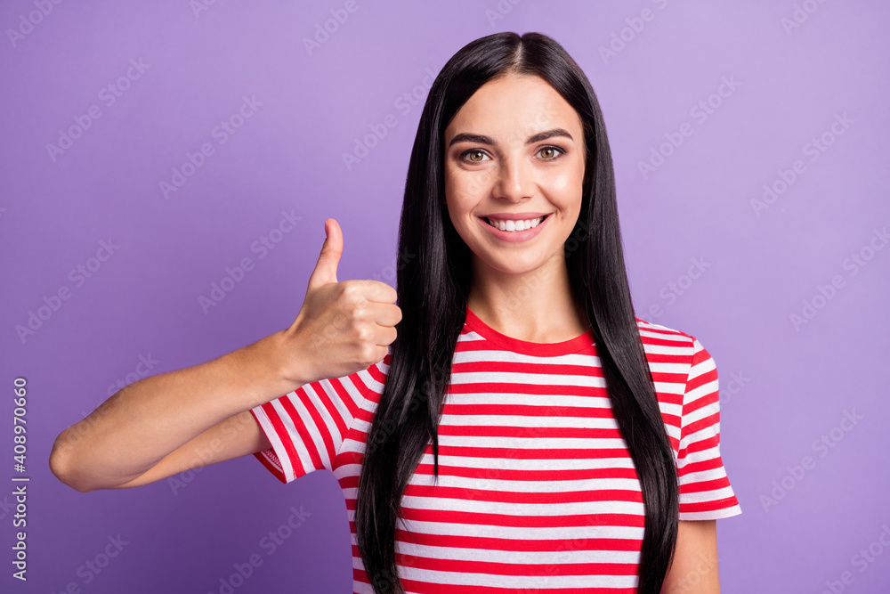 Photo of charming young girl raise thumb up look camera wear striped red shirt isolated violet color background Photo of charming young girl raise thumb up look camera wear striped red shirt isolated violet color background