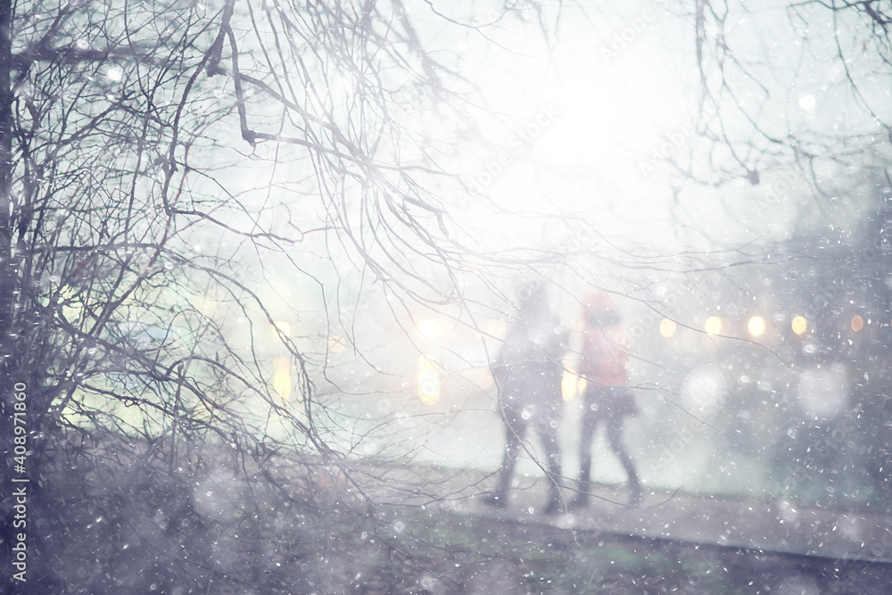 couple in love on a christmas walk in the city, evening snowfall december holiday new year