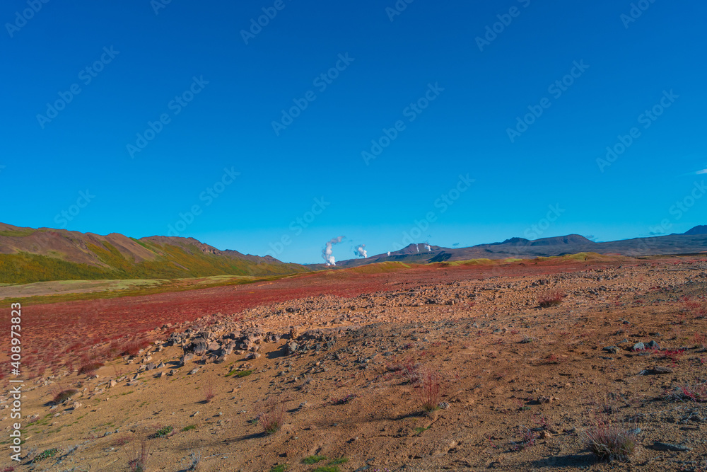 Colorful geothermal active zone Hverir near Myvatn lake in Iceland, resembling Martian red planet landscape, at summer and blue sky.