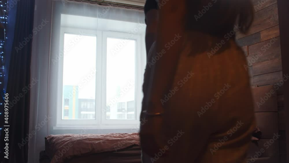 Young couple walks in the bedroom and laying down on the bed Young couple walks in the bedroom and laying down on the bed