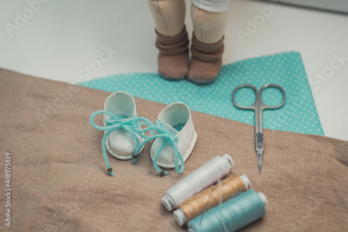 on the table lay a pair of scissors thread fabric for patchwork shoes and doll crafts classes quarantined