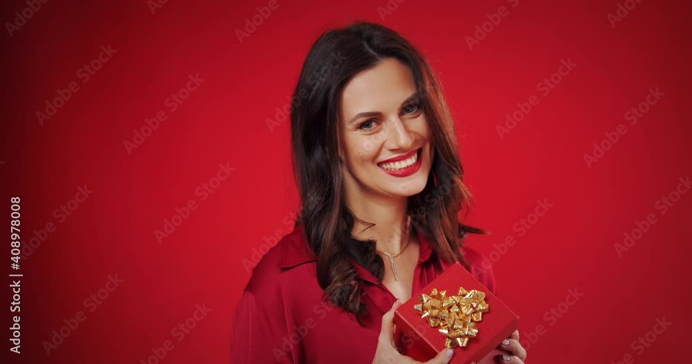 beautiful woman enjoys a valentine's gift on a red background beautiful woman enjoys a valentine's gift on a red background