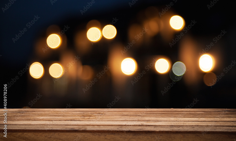Wooden table top on blurred shop window of cafe with light bulb. Background for product display montage or key visual design. Wooden table top on blurred shop window of cafe with light bulb. Background for product display montage or key visual design.