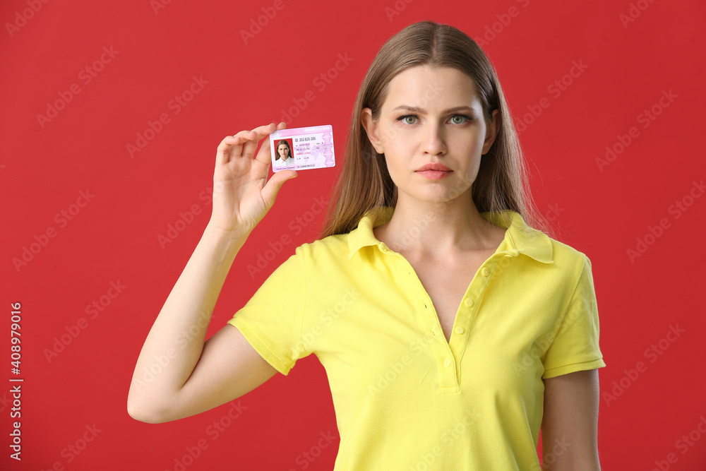 Young woman with driving license on color background Young woman with driving license on color background
