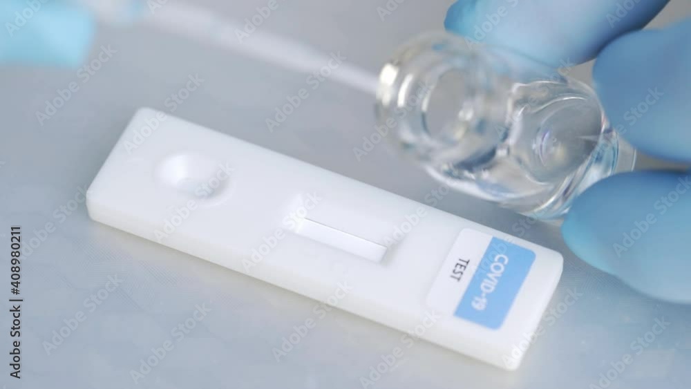 Crop faceless doctor dropping reagent on express coronavirus test stick Crop faceless doctor dropping reagent on express coronavirus test stick