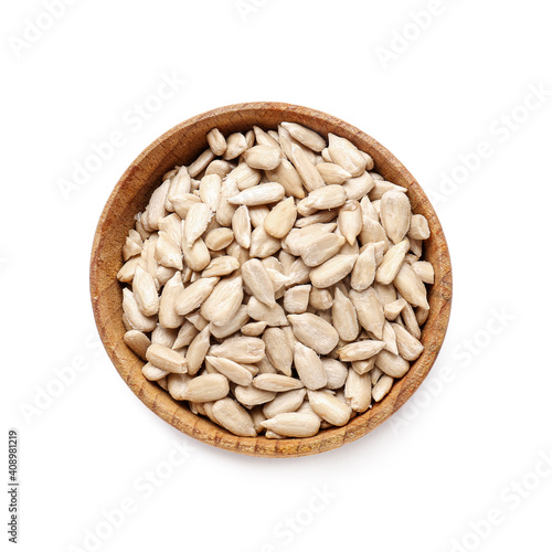 Bowl with peeled sunflower seeds on white background