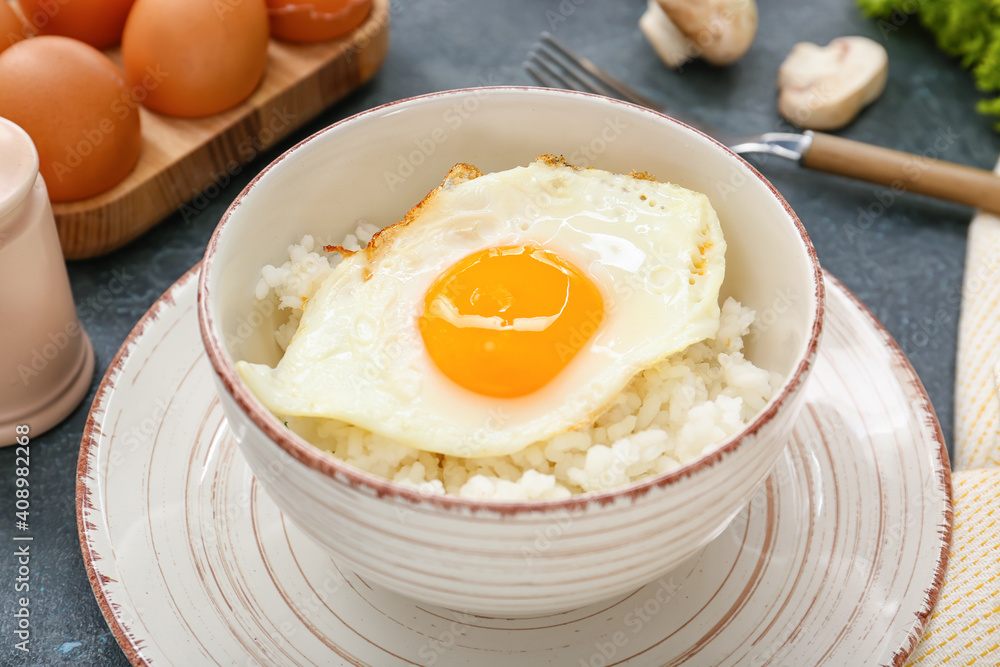 Bowl with tasty egg and rice on dark background Bowl with tasty egg and rice on dark background