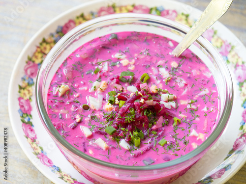 Cold beet soup with eggs, cucumbers, radishes and greens on a decorative porcelain plate