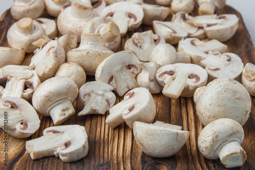Close-up of whole and sliced mushrooms lying on a dark wooden board