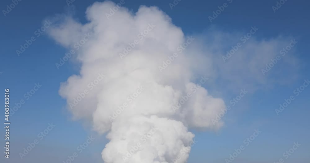 Emission of smoke from the pipe, polluting the environment, white smoke on a background of blue sky Emission of smoke from the pipe, polluting the environment, white smoke on a background of blue sky