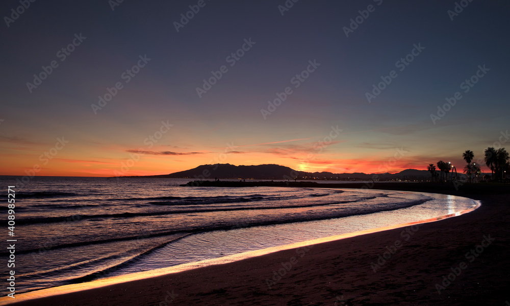 sunset with mountains and mediterranean sea, orange yellow sky