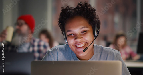 Call center agent with headset working on support hotline in modern office photo