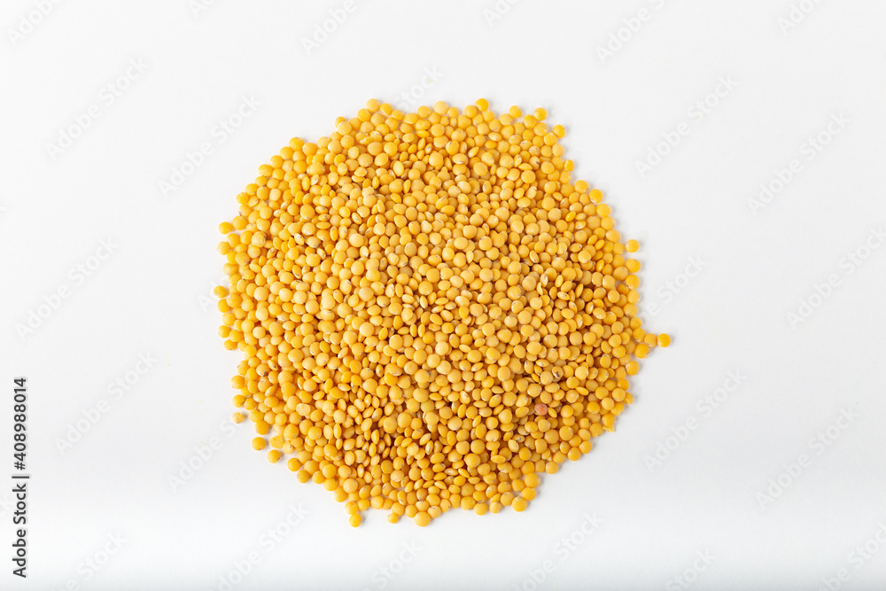 Pile of yellow lentils on white background.