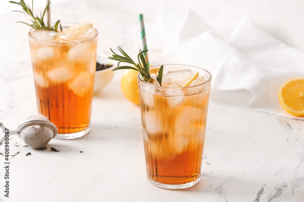 Glasses of cold black tea with lemon on light background Glasses of cold black tea with lemon on light background