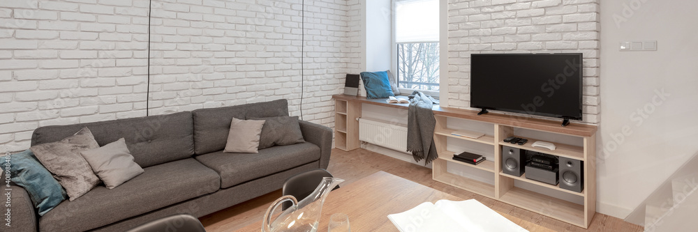 Small living room with brick walls, panorama