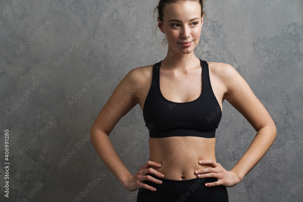 Fototapeta premium Young cheerful smiling woman in sports wear standing