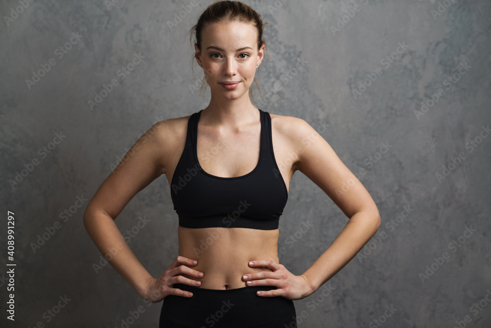 Fototapeta premium Young cheerful smiling woman in sports wear standing